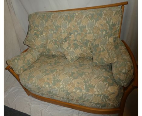 A good quality modern Ercol light elm two-seat sofa and matching tub arm chair with floral upholstered cushions