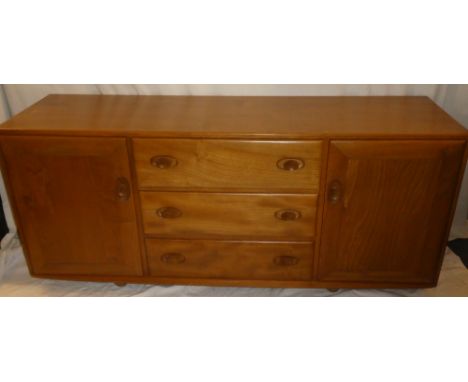 A good quality Ercol light elm sideboard with three central drawers flanked by cupboards enclosed by two panelled doors 61" l