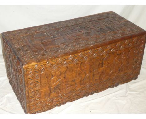 A good quality African carved wood rectangular trunk decorated all over with numerous figures and geometric patterns 35" long