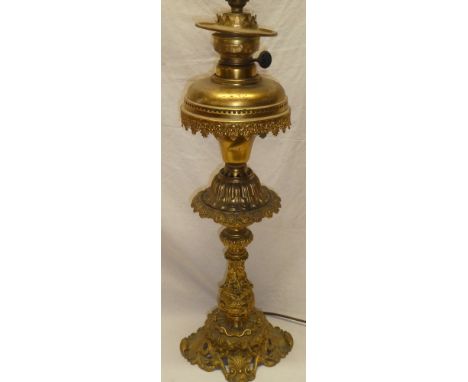 An ornate brass table lamp, converted from an oil lamp by Matador with raised scroll decoration, 22" high