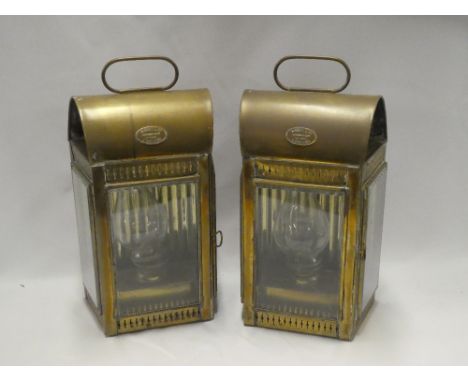 A pair of brass nautical lamps by Davey &amp; Co. London with oil lamp fitments in glazed arched cases 17" high overall