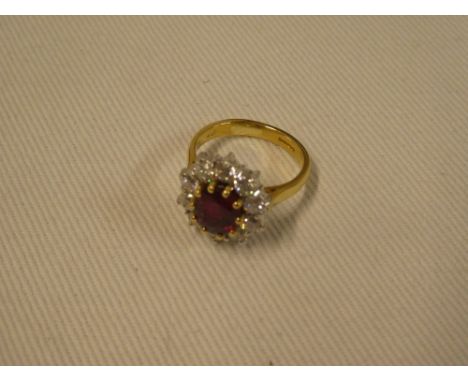 An 18ct gold dress ring set central ruby surrounded by ten brilliant cut diamonds