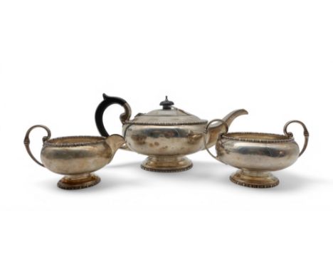 A three piece silver tea service, by Walker &amp; Hall, Sheffield 1920, of squat circular form, with a beaded rim, with eboni