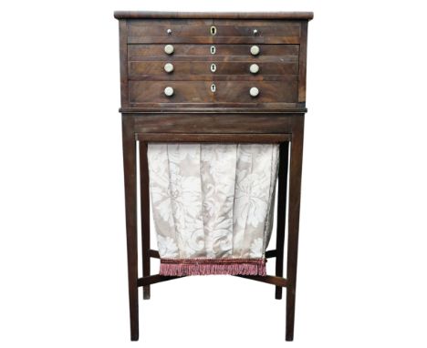 A Victorian walnut sewing work table with hinged top over two lined drawers over fabric hamper drawer on square tapering supp