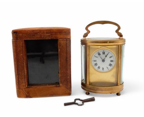 An oval brass and glass carriage clock, with Roman Numerals on a white enamel dial, with key and travel case Condition Report