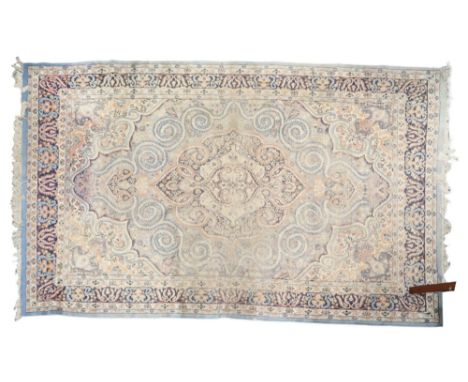 A light blue ground Tabriz style rug with cream central medallion and matching spandrels on floral patterned ground within da