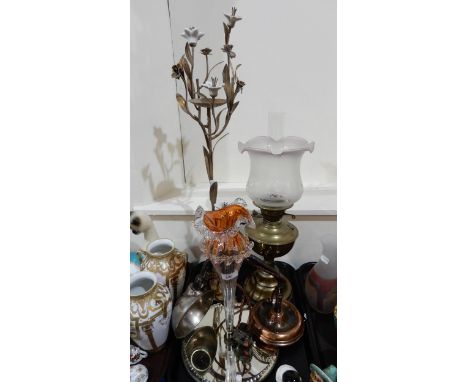 A red and clear glass flute on mirrored plateau, a gilded and white ceramic flower candlestand, a brass oil lamp and another 