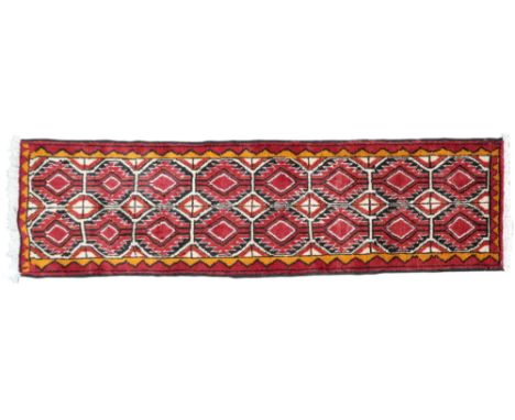 A cream ground Turkoman runner with red and black geometric patterned ground and red and orange border, 183cm long x 52cm wid