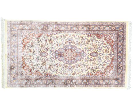 A cream ground Isfahan style rug with ochre central medallion and matching spandrels on floral patterned ground within blue f