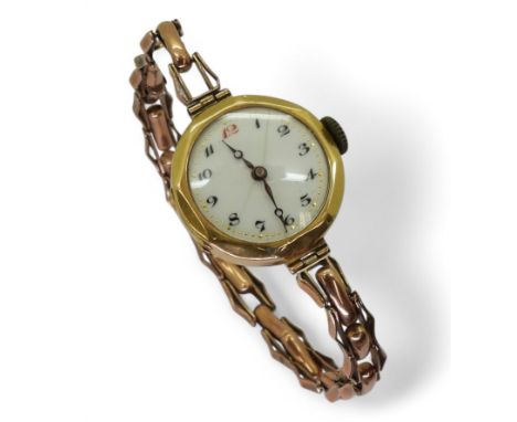 A ladies vintage watch with a 18ct gold head hallmarked with London import marks for 1928, with a 9ct gold strap approx weigh