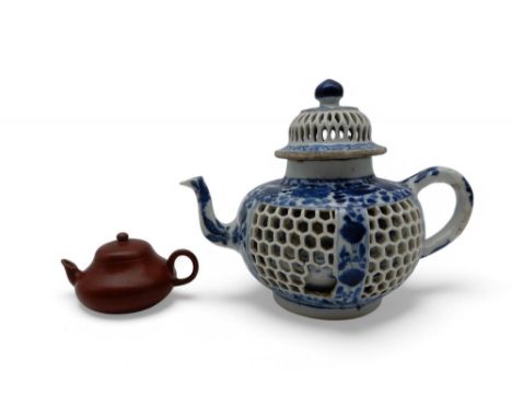 A Chinese blue and white reticulated teapot painted with flowers, Kangxi,14.5cm high together with a Yixing miniature teapot,