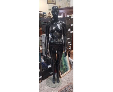 Modern freestanding full size black retail female mannequin. 