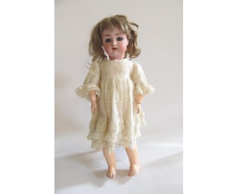 A Kammer &amp; Rheinhardt bisque head doll with blue glass sleeping eyes, open mouth and teeth, auburn mohair wig, jointed co