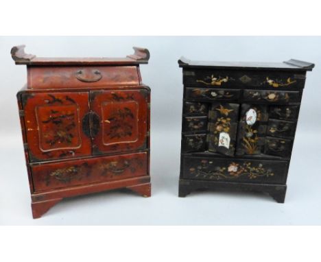 A Japanese black lacquered table cabinet with gilt floral and bird decoration and inset porcelain panels, comprising hinged t