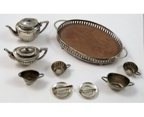An Edwardian silver miniature tea service, Birmingham 1905/08, comprising two tea pots, sugar bowl with tongs, milk jug (both