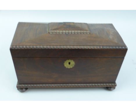 A Victorian rosewood tea caddy of sarcophagus shaped form with gadrooned edges, the hinged lid opening to reveal a fitted int