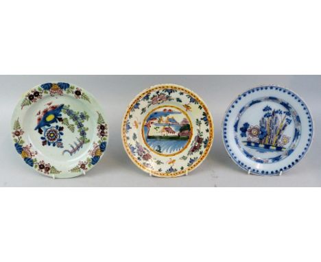 Three 18th century Delft polychrome decorated plates comprising one with bamboo and flowers within a beaded border in blue, m