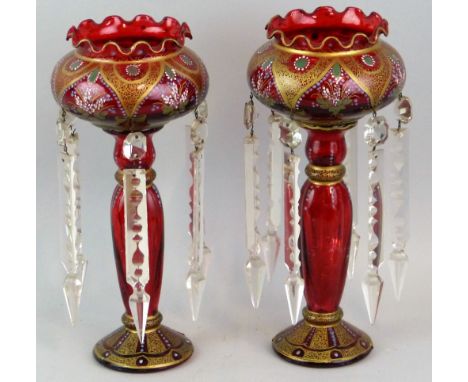 A pair of lustre vases, the ruby painted clear glass bodies decorated with alternate gilded and floral panels and each hung w