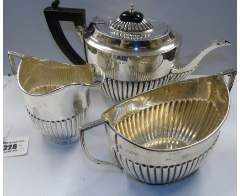 A Silver Half Reeded Three Piece Tea Service; the teapot Birmingham 1907, the sugar basin and jug , London: William Sutton & 