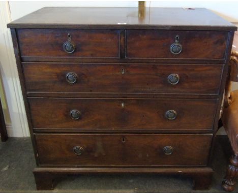 A Georgian Mahogany Chest of Drawers, having two short over three long drawers and standing on bracket feet.