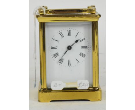 An early 20th century brass carriage clock. The clock having white face with black roman numeral to chapter ring, raised over