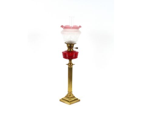 A Victorian brass Corinthian&nbsp;column table oil lamp, with ruby reservoir and tinted shade, 59cm high