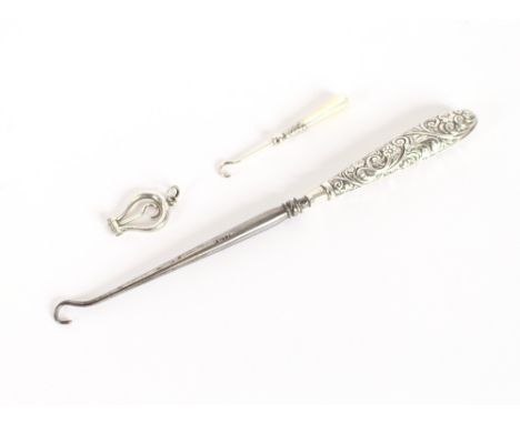 A late Victorian silver foliate handled button hook, Birmingham 1899; a small folding silver button hook and another with mot