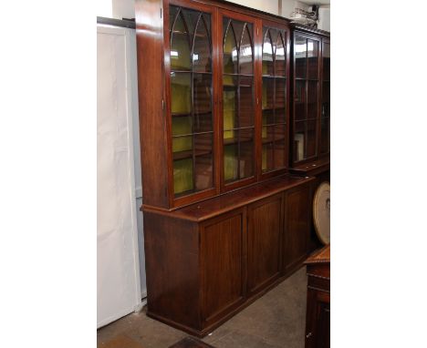 A large 19th Century mahogany bookcase, the upper adjustable shelves enclosed by three glazed astragal doors, cupboards below