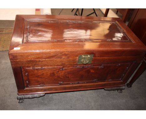 A Chinese camphor wood trunk, raised on squat carved cabriole supports, 106cm wide