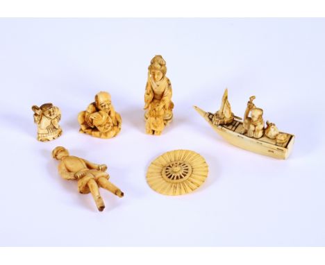 An Antique carved ivory Netsuke, in the form of a face mask seller; an ivory figure of a fisherman on his boat; another carve