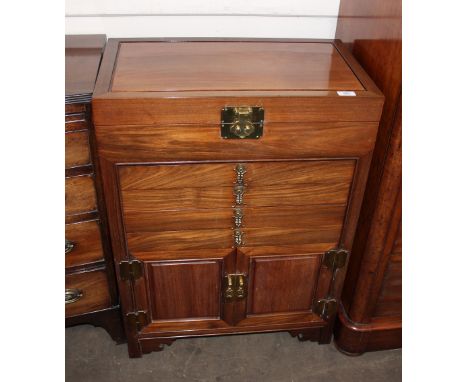 An oriental hardwood canteen/side cabinet, with lifting top above four shallow drawers and cupboard below, raised on bracket 