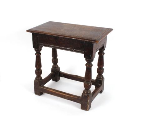 An Antique oak joint stool, the overhanging top raised on turned baluster supports united by stretchers, 44cm