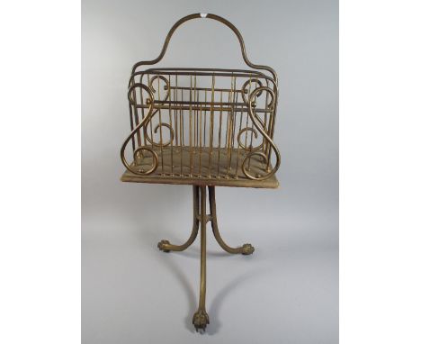 A Brass Four Division Magazine Rack with Tripod Base and Claw Feet 