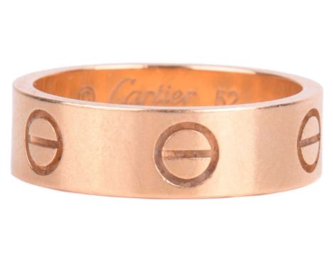 Cartier - an 18ct yellow gold 'Love' ring, flat polished band decorated with screw-head motifs, signed and numbered, struck w