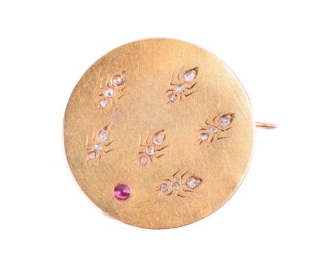 An Art Nouveau gem-set brooch depicting a colony of ants, the circular disc highlighted by a ruby cabochon, attracting ants t