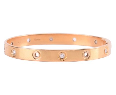 Cartier - a diamond-set hinged bracelet in 18ct yellow gold, set with six brilliant-cut diamonds of 2.5 mm, with an estimated