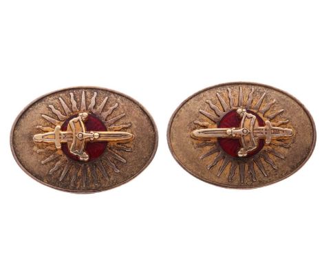 A pair of cufflinks of heraldry design, the oval plaques centred with a crowned sword applied upon a red guilloché enamel pan