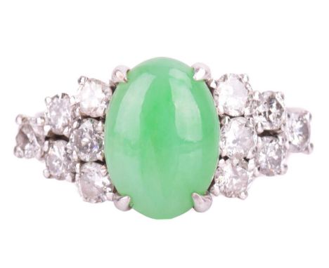 A jade and diamond dress ring, centred with an oval jadeite cabochon light pale green colour, approximately measures 10.4 x 7