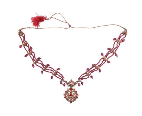 An Indian ruby, paste and enamel necklace, the central pendant set with cabochon rubies in an open work design in yellow meta