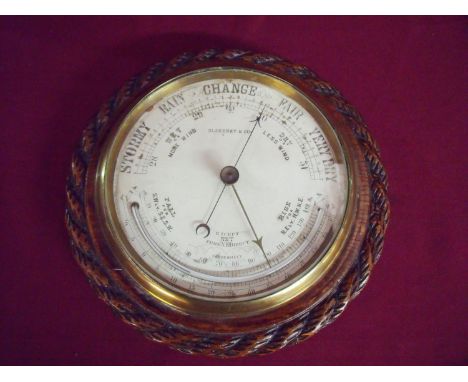Carved oak rope twist cased wall barometer by Blakeney &amp; Co (diameter 24cm) 