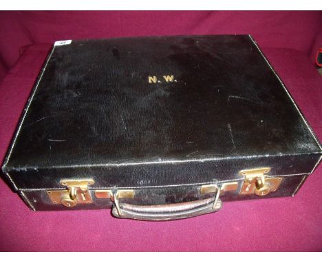 Early 20th C black leather travelling case with gilt letters and brass locks, revealing fitted interior with travelling light