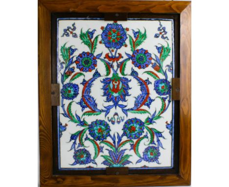 A wonderful hand made Iznik style tile in a wooden frame. The expressive colours and botanical decorations make this piece a 