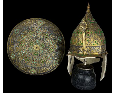 This helmet and shield date back to the early 20th century. It is ornately decorated with many gold inlays and adorned with r