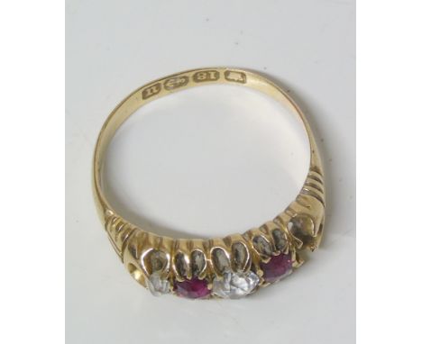 A late Victorian 18ct gold diamond and ruby five stone ring, the old cut diamond and circular shape ruby line with scrolling 