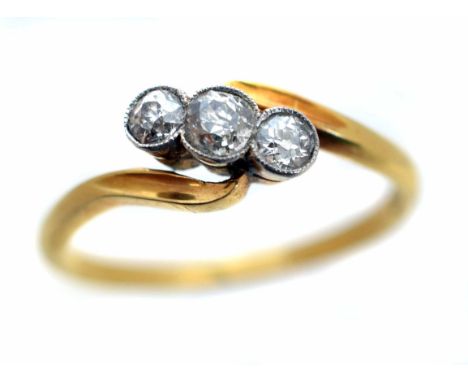 An early 20th Century diamond three stone ring, the graduated old cut diamond line within a shared collet setting, to the cro