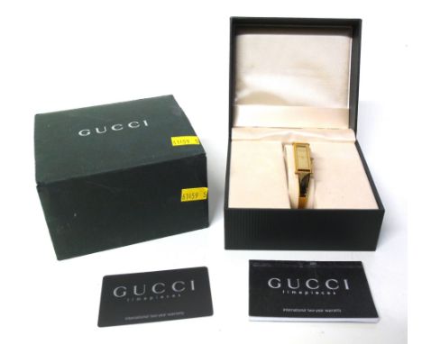 A ladies Gucci quartz wristwatch, the rectangular signed gold dial with hinged bangle bracelet and horsebit folding clasp, re