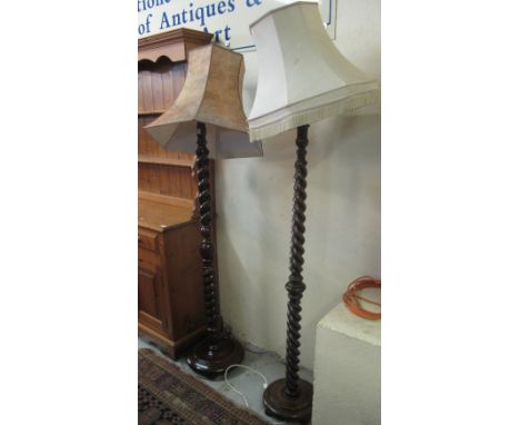 Two similar oak barley twist standard lamps on circular stepped bases with shades. (2)(B.P. 24% incl. VAT)   CONDITION REPORT