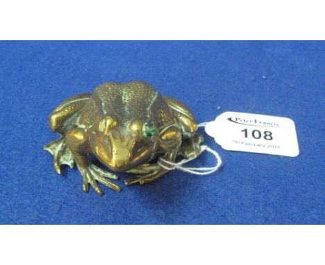 Brass or bronze paperweight in the form of a crouching frog, originally with jewelled eyes, one now missing. 9cm.(B.P. 24% in