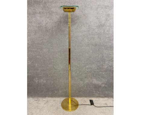 A contemporary brass standard lamp uplighter with a moulded floral design and a thick plate glass shade. H.186cm