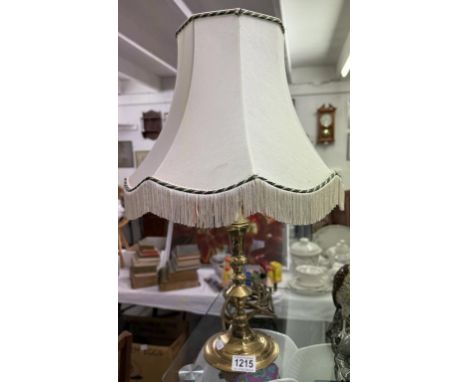 A brass table lamp with shade